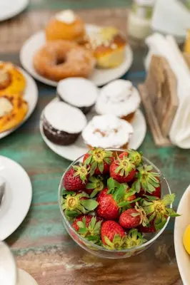 a table with plates of donuts and a bowl of strawberries at Ai Tre Mercati in Palermo