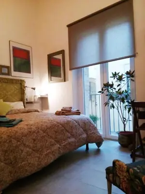 a bedroom with a bed and a large window at Arimatea Accommodations in Palermo