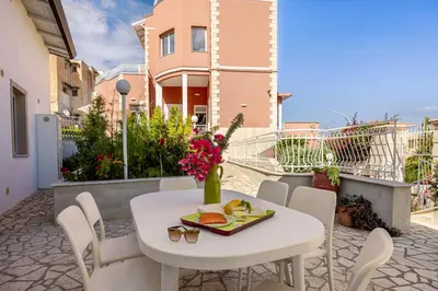 a white table and chairs with a plate of food at Villa Edera Rental Room in Santa Flavia