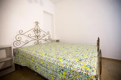 a bedroom with a bed with a floral bedspread at Appartamenti Duchessa in Castellammare del Golfo