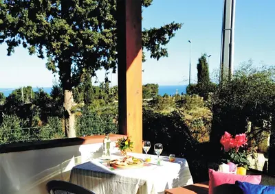 a table with a plate of food and wine glasses at Villette di Scopello - Casa Vacanze in Scopello