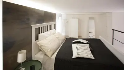 a bedroom with a black and white bed with pillows at SpAsimoH-1 in Palermo