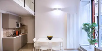 a kitchen with a white table and white chairs at SpAsimoH-1 in Palermo