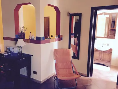 a chair in a room with a desk and a mirror at Villa della Mimosa in Alia