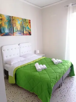 a bedroom with a large bed with a green blanket at Casagioiosa18 in Palermo