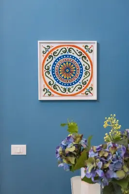 a picture on a blue wall with a painting on it at casa mo room and suite in Palermo