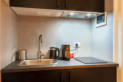a kitchen counter with a sink and a coffee maker at casa mo room and suite in Palermo
