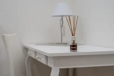 a white table with a vase with sticks in it at A casa di Antonietta in Palermo