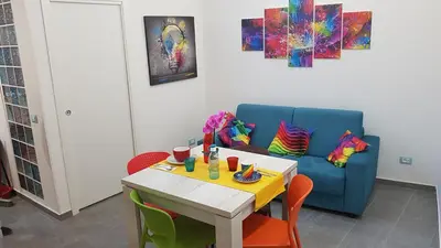a dining room with a table and a blue couch at Arco del Sole 2 in Palermo