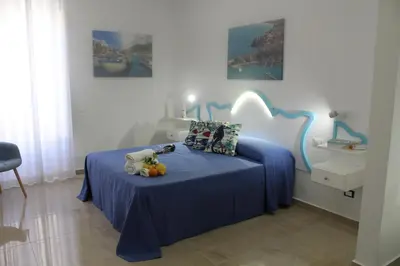 a bedroom with a bed with blue sheets and pillows at EXCLUSIVE HOME in Castellammare del Golfo