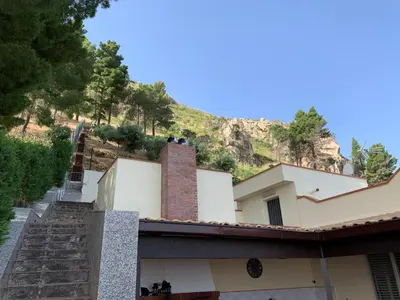 a building with a mountain in the background at Villa Ibiscus in Mandra Capreria