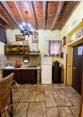 a kitchen with a refrigerator and a table in it at La casetta del vicoletto in Palermo