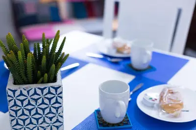 a blue table with a vase with a plant on it at MiKlod Apartments in Palermo