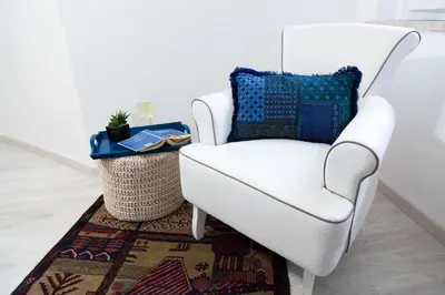 a white chair sitting next to a rug at MiKlod Apartments in Palermo