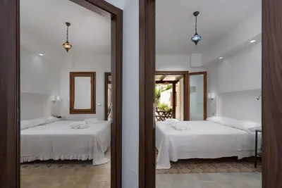two beds in a room with a mirror at Finisterre in San Vito lo Capo