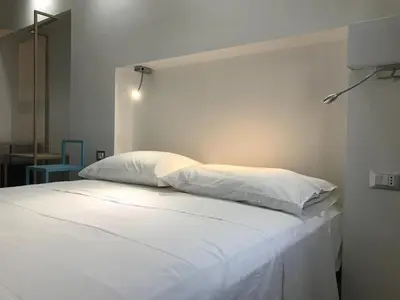 a white bed with two pillows on top of it at Finisterre in San Vito lo Capo