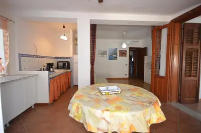 a kitchen with a table in the middle of a room at Villetta SanVito - Sunrise & Sunset in San Vito lo Capo