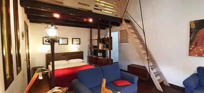 a living room with a loft bed and a blue couch at Palermo Holiday Studio in Palermo