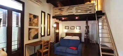 a bedroom with a bunk bed and a blue chair at Palermo Holiday Studio in Palermo