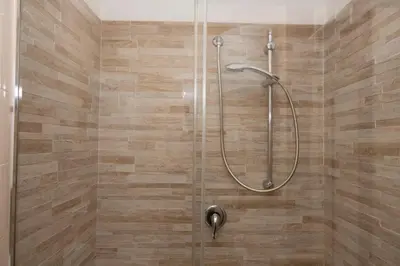 a bathroom with a shower with a glass door at Appartamento Conturrana Sul Mare in San Vito lo Capo
