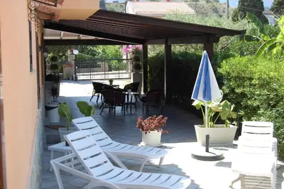 a group of chairs and an umbrella on a patio at Sunrise in Lascari