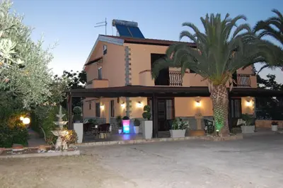 a house with a palm tree in front of it at Sunrise in Lascari