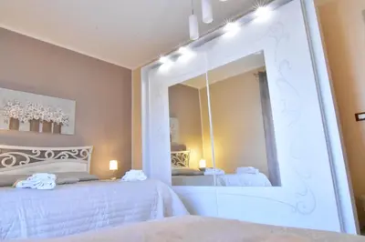 a bedroom with two beds and a large mirror at Bed and Breakfast Il Girasole in Mondello