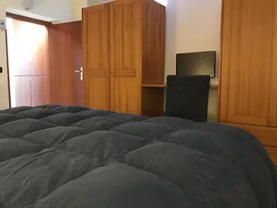 a bedroom with a bed and a desk with a television at Palazzo Gallo in Palermo