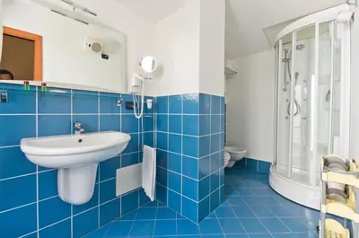 a blue tiled bathroom with a sink and a shower at Palazzo Gallo in Palermo