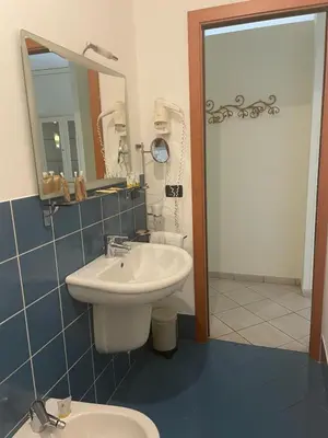 a bathroom with a sink and a toilet and a mirror at Palazzo Gallo in Palermo