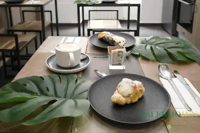 a table with two plates of food and a cup of coffee at Palermo Inn Suite in Palermo