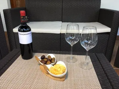 two wine glasses and a bowl of chips and a bottle of wine at Armida House - Mondello in Mondello