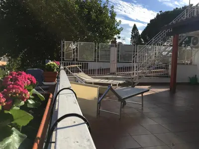 a balcony with a bench and flowers on a roof at Armida House - Mondello in Mondello