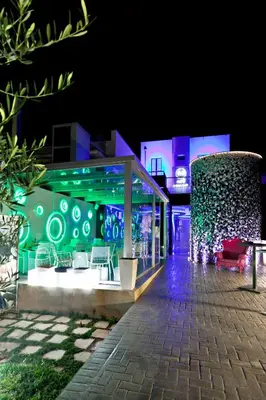a building with green lights on it at night at Mille e Una Notte in Nuova Gibellina