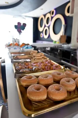 a row of donuts on trays in a bakery at Mille e Una Notte in Nuova Gibellina