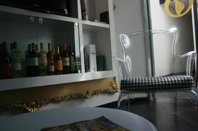 a room with a chair and a shelf with wine bottles at Mille e Una Notte in Nuova Gibellina