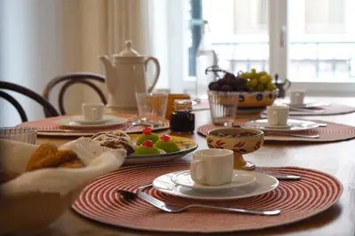 a table with plates of food and a bowl of fruit at T-home / Stylish apartment Palermo center in Palermo