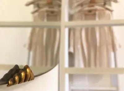 a mirror reflection of a group of bullets on a shelf at T-home / Stylish apartment Palermo center in Palermo