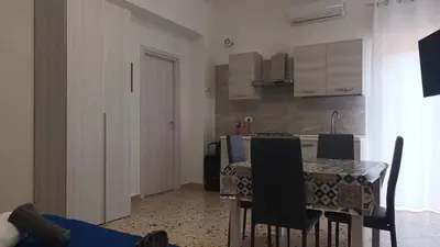 a kitchen with a table and chairs in a room at Apartments Bed Abate in Villabate