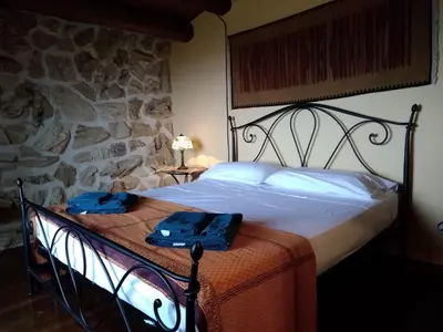 a bedroom with a bed with two blue towels on it at Ziba Villa Siciliana con piscina e vista panoramica sul mare in Borgetto