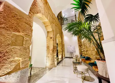 a room with a stone wall and a table and chairs at Palazzo del Poeta - Dimora Contemporanea in Palermo