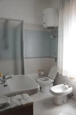 a bathroom with a toilet and a tub and a sink at Katia appartamenti in San Vito lo Capo