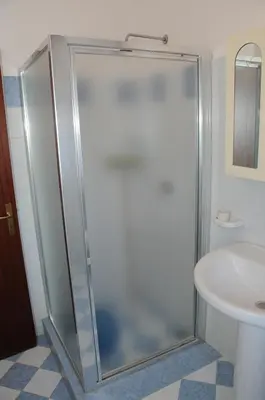 a glass shower in a bathroom with a sink at Katia appartamenti in San Vito lo Capo