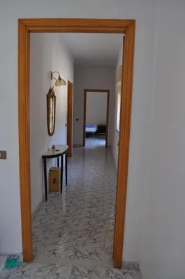 a hallway with a door open to a room with a table at Summerhouse Sagana in Monreale