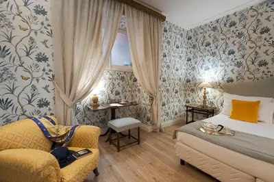 a hotel room with a bed and a chair at Palazzo Arone dei Baroni di Valentino in Palermo