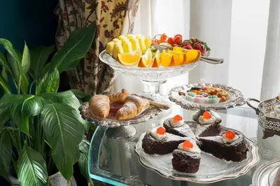 a tray of cakes and pastries on a glass table at Palazzo Arone dei Baroni di Valentino in Palermo