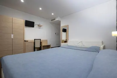 a bedroom with a large bed and a projection screen at Alaba Hotel in San Vito lo Capo