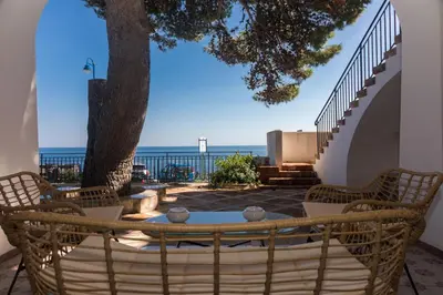a patio with a table and chairs and a tree at Villa Mallandrino in Mondello
