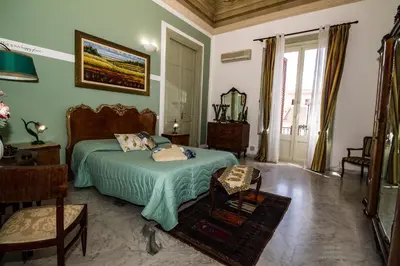 a bedroom with a bed with a green comforter at Cavour Il Conte Camillo in Palermo