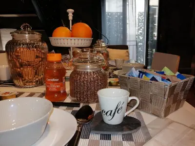 a table with a cup of coffee and jars of food at Palazzo Rea in Palermo